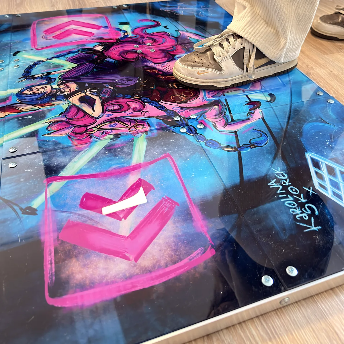 03-prox-obraz-detal-1200x1200-1 - Interactive Mats L-TEK Gros plan d’un panneau flèche imprimé de la L-TEK PRO X, impression UV brillante, une chaussure sur le tapis