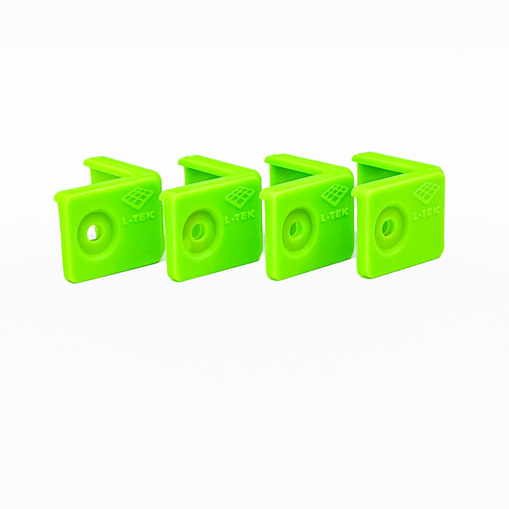 Four green L-TEK corner bumpers shown against a white background