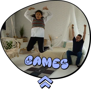 Frame-1294 - Interactive Mats L-TEK Playful circular badge advertising games: two kids jumping with 'GAMES' in blue bubble text and a blue up-arrow beneath.