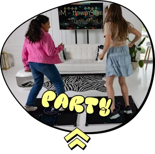 Frame-1295 - Interactive Mats L-TEK Two girls dancing in a bright living room with a white couch and a party screen reading 'PARTY!' in the background (party scene).