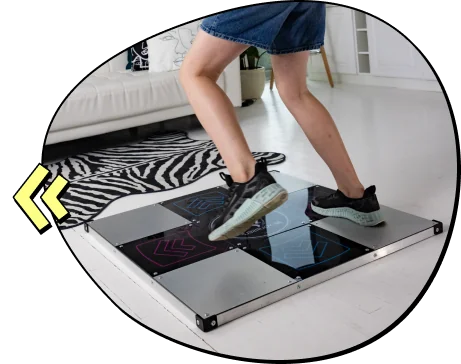 Group-154 - Interactive Mats L-TEK Person wearing sneakers steps on a dance pad in a bright living room, mid-dance motion.