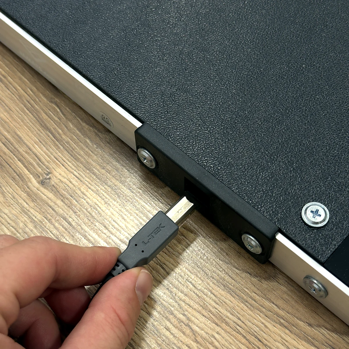 sq-ltek-core-usb-connection - Interactive Mats L-TEK Hand plugging a USB cable into the socket built into the side of the L-TEK Core dance pad