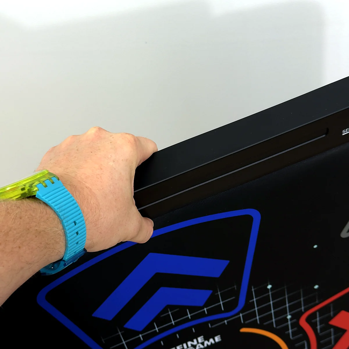 sq-nlgm-carried-in-one-hand - Interactive Mats L-TEK Hand lifting the L-TEK Next Level Gaming Mat by the electronics bar along its top edge