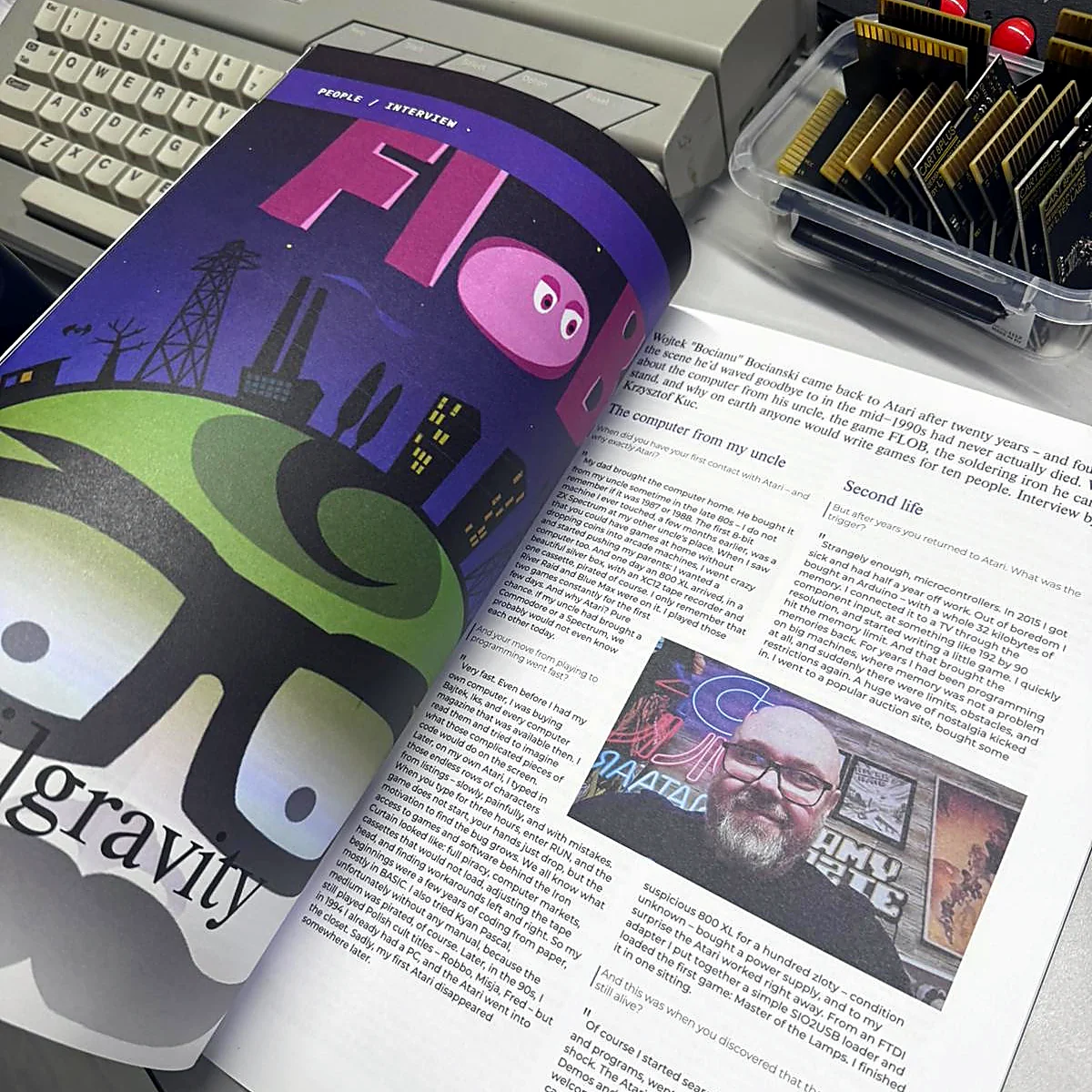 sq-nr01-demoscene-art-spread - Interactive Mats L-TEK Atari Legacy Issue 01 open at a demoscene feature with large colour artwork and a photograph of a scene member