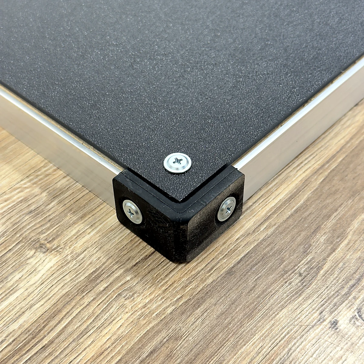 sq-prime-aluminium-frame-corner - Interactive Mats L-TEK Close-up of the brushed aluminium frame and black corner protector of the L-TEK Prime dance pad
